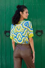 Remera de tejido de punto con estampa abstracta en colores blanco, azul y verde. De calce recto, con cuello redondo y manga corta.