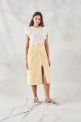 Blusa sin mangas color crema con bordado floral, cuello mao y volados en los hombros.