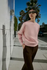 Jersey de punto liso con cuello redondo y manga larga, con detalle de costura en forma de V en el cuello.