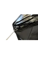 Sobre de mano tipo clutch confeccionado en charol negro brillante con solapa geométrica y cadena metálica plateada delgada.