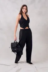 Chaleco negro con escote halter, corte al cuerpo y cierre frontal con botones.