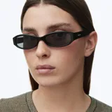 Lentes de sol Titi All Black con armazón ovalado alargado de acetato negro brillante y lentes oscuros polarizados.