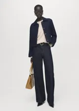 Chaqueta de algodón estilo denim en color azul oscuro, con cuello camisero, bolsillos de parche con solapa en el pecho y cierre frontal con botones.