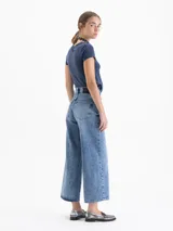 Jeans de denim 100% algodón, color azul claro con efecto desgastado. Modelo wide leg cropped, de tiro alto y calce relajado.
