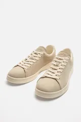 Zapatillas bajas color beige de gamuza, con cordones y suela de goma.