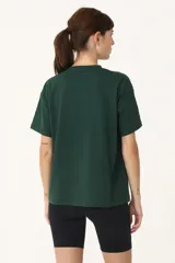 Remera verde con cuello redondo y manga corta. Estampado frontal con la palabra "Basset" en color blanco.
