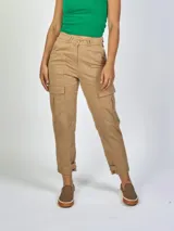 Pantalón cargo gris oscuro, de tiro alto, corte recto y calce relajado, con bolsillos laterales y bolsillos ocultos con tapa a media pierna. Detalle de pasacintos dobles y presilla ajustable con doble botón en los bajos.