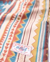 Short de baño de microfibra con estampado geométrico en tonos beige, marrón, naranja y celeste. Tiene cintura elástica con cordón ajustable, dos bolsillos laterales y un bolsillo trasero.