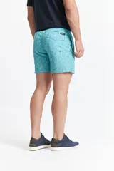 Short de baño celeste con estampado de motivos marinos en blanco. Tiene cintura elástica con cordón ajustable, dos bolsillos laterales y uno trasero.