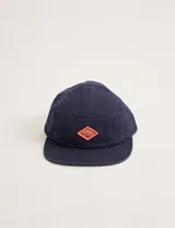 Gorra azul marino de algodón con visera recta y parche con logo en forma de rombo en el frente.