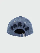 Gorra de béisbol azul denim con logo "AMI" bordado en negro en el frente.