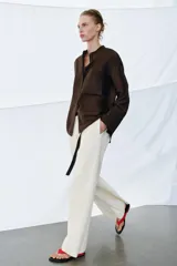 Camisa ZW Collection de color marrón oscuro, con cuello mao, manga larga con puños anchos y cierre frontal oculto por solapa. Cuenta con un bolsillo de parche en el pecho adornado con bordados a tono, los cuales también se repiten en los puños.