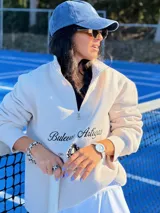 Gorra tipo baseball de color azul con efecto lavado, con bordado frontal de un escudo con una piña en el centro.