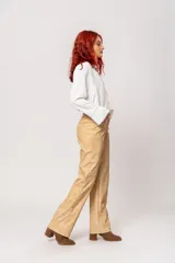 Pantalón de tiro alto color beige con estampado difuminado, bolsillos laterales y cierre frontal con cremallera y botón.