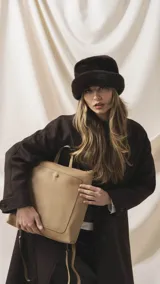 Mochila de diseño moderno y funcional, confeccionada en símil cuero con textura granulada. Cuenta con un bolsillo frontal con broche, cierre principal superior, manija superior y correas ajustables. Incluye logo de la marca grabado en el frente.