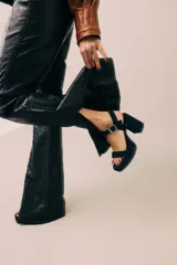 Sandalias de tacón alto, color negro, con dos tiras en el empeine y hebilla lateral.