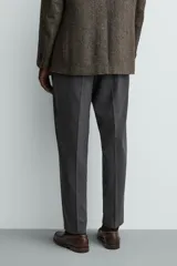 Pantalón de vestir regular fit color negro, confeccionado en tejido con mezcla de lana y elasticidad. Cuenta con cintura elástica, bolsillos frontales, bolsillos traseros de vivo con botón, y cierre frontal con cremallera y botón.