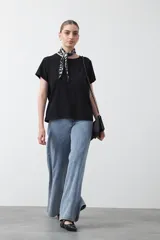 Remera básica de manga corta en color blanco, con cuello redondo y detalle de pliegues sutiles en los hombros.