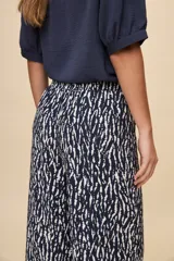Pantalón gris de corte amplio y silueta fluida, con cintura elástica y cordón ajustable.