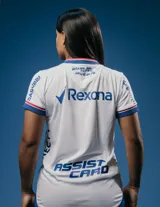 Camiseta de fútbol Umbro del Club Nacional de Football, modelo Home Oficial 2025 para mujer. Diseño en color blanco con detalles tricolores en los hombros, cuello y mangas, y el escudo del club bordado en el pecho junto al logo de Umbro y patrocinadores.