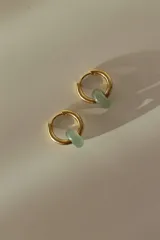 Par de aros tipo argolla dorados de acero quirúrgico, con una piedra natural de color gris translúcido colgando de cada uno.