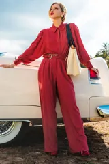 Pantalón palazzo rojo con finas rayas verticales blancas, de tiro alto y corte holgado.