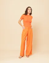 Pantalón de lino color naranja, de tiro alto y corte wide leg.