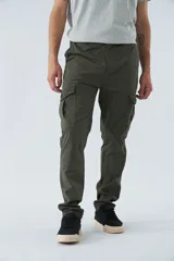 Pantalón cargo gris oscuro, corte slim, con cierre de botón y cremallera, trabillas para cinturón y bolsillos cargo con botón.