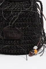 Bolso mini tipo bombonera de color marrón oscuro, confeccionado con tejido trenzado y detalles de flecos colgantes. Cuenta con cierre de cordón ajustable y correa cruzada trenzada.