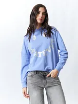 Canguro lila con capucha y cordones ajustables. Estampado frontal con la palabra "Whatever" en letras plateadas.