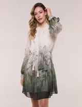 Vestido corto de gasa estampada con motivos botánicos en tonos verdes y crudo, diseñado por Julia Jordan. Cuenta con cuello alto con lazo para atar, abertura frontal con botones, delantera plisada, mangas largas abullonadas y un lazo ajustable en la cintura. Incluye forro interno.
