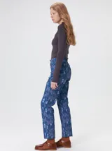 Pantalón de jean de tiro medio con corte de pierna recta y ajuste cómodo. Presenta un estampado integral con motivos geométricos y abstractos en tonos azules.
