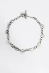 Collar de cadena de eslabones plateados con dijes en forma de corazón distribuidos a lo largo de la pieza. Cuenta con un cierre de barra en T.