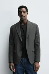 Blazer slim fit de estructura con diseño de pata de gallo, cuello con solapas de muesca, manga larga con botones en puños, bolsillos de solapa en cadera y cierre frontal con botones.