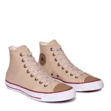 Championes Converse modelo Chuck Taylor All Star de caña alta, confeccionados en lona color beige. Presentan el parche clásico con el logo de la marca en el lateral, puntera de goma y suela de caucho con detalles en rojo.