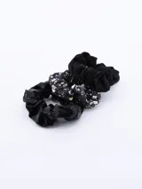 Pack de tres coleros para el pelo, uno de terciopelo negro, uno de tela negra con estampado de flores blancas y verdes, y uno de tela lisa negra.