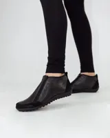 Zapato bajo de cuero negro con puntera redondeada y cierre frontal con cremallera doble.