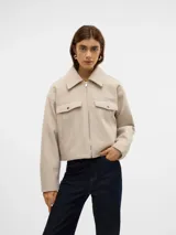 Chaqueta corta color beige con cuello con solapa y bolsillos en el pecho con cierre de botón.