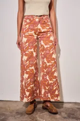 Jean wide leg de tiro medio, con estampado botánico en tonos terracota y beige, confeccionado en denim de algodón con elastano.