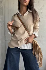 Sweater de punto en color beige, con cuello redondo, mangas largas con puños acanalados y diseño de corte holgado.