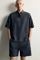 Sudadera relaxed fit confeccionada en tejido interlock de algodón con elasticidad, cuello redondo y manga corta, de color negro.