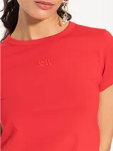 Remera blanca de algodón pima y elastano, corte ajustado, manga corta, cuello redondo y largo hasta la primera cadera.