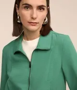 Campera bomber femenina color beige claro, confeccionada en tejido Airflow texturado. Presenta cuello solapa, cierre frontal de cremallera y puños y bajo elásticos.