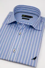 Camisa de vestir Club House de corte clásico, color celeste con sutiles rayas verticales oscuras, cuello italiano corto y bordado de un pájaro en el frente.