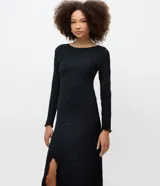 Vestido largo de malla texturizada con cuello redondo y manga larga. Presenta un corte evasé con acabado de encaje discreto, ofreciendo una caída fluida y elegante.