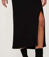 Falda midi negra de rib, con abertura lateral.