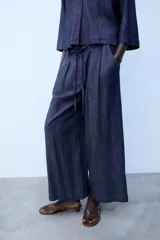 Pantalón de tiro medio color azul, corte ancho y fluido, con cintura elástica fruncida y cordón ajustable.