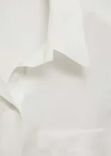 Camisa blanca sin mangas de lyocell con cuello camisero, bolsillo de parche en el pecho y cierre frontal con botones.