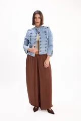 Pantalón marrón fluido de corte ancho y relajado, con cintura elástica fruncida y diseño abombado en las piernas.