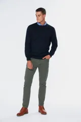 Pantalón de vestir azul marino, de corte recto, con bolsillos laterales y traseros. Se ajusta a la cintura con cinturón de cuero marrón.